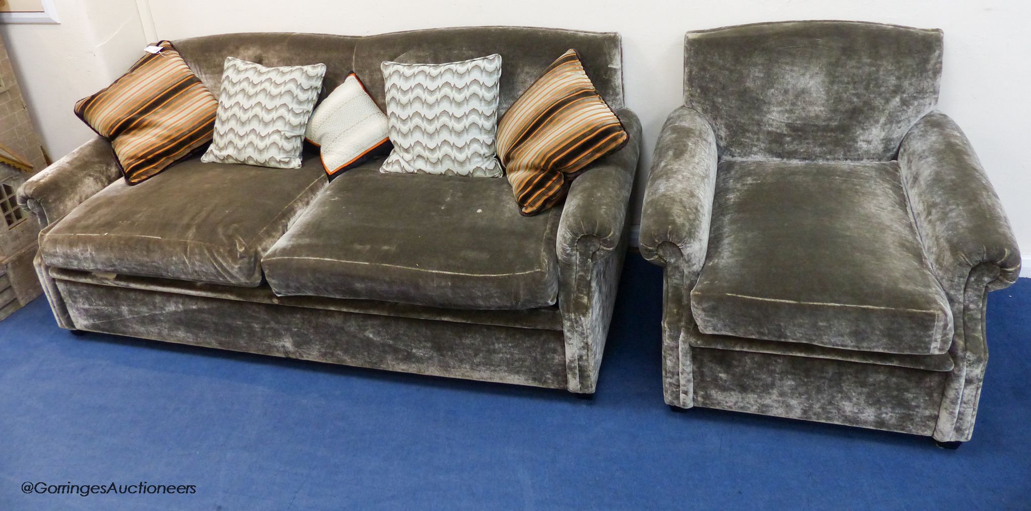 A grey velvet two seat sofa bed, approximately 191 cm wide and a matching armchair, various scatter cushions